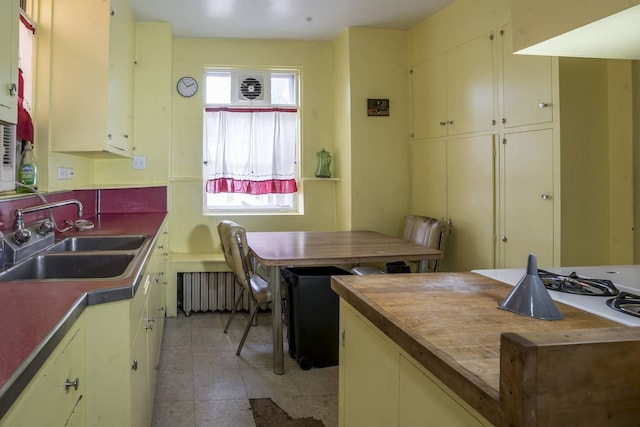 2206 W Lunt Ave, Chicago, IL 60645 - kitchen featuring a sink, radiator, cream cabinetry, and light tile patterned floors