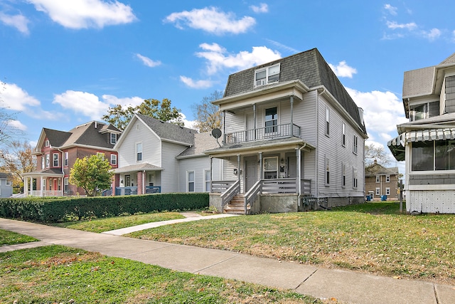 view of front facade featuring a front yard, covered porch, and a balcony