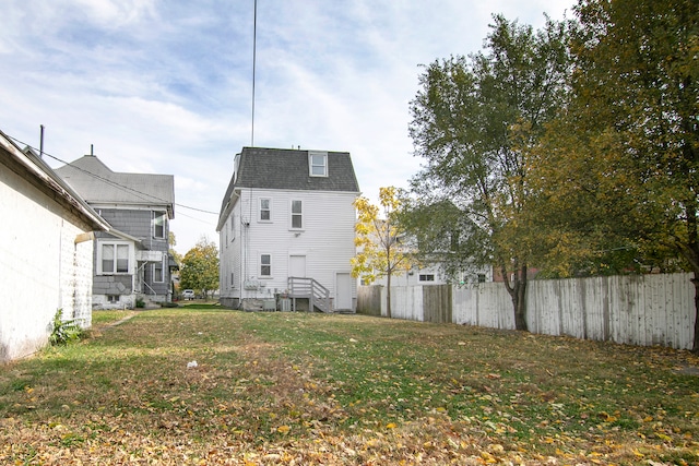 back of house with cooling unit and a yard