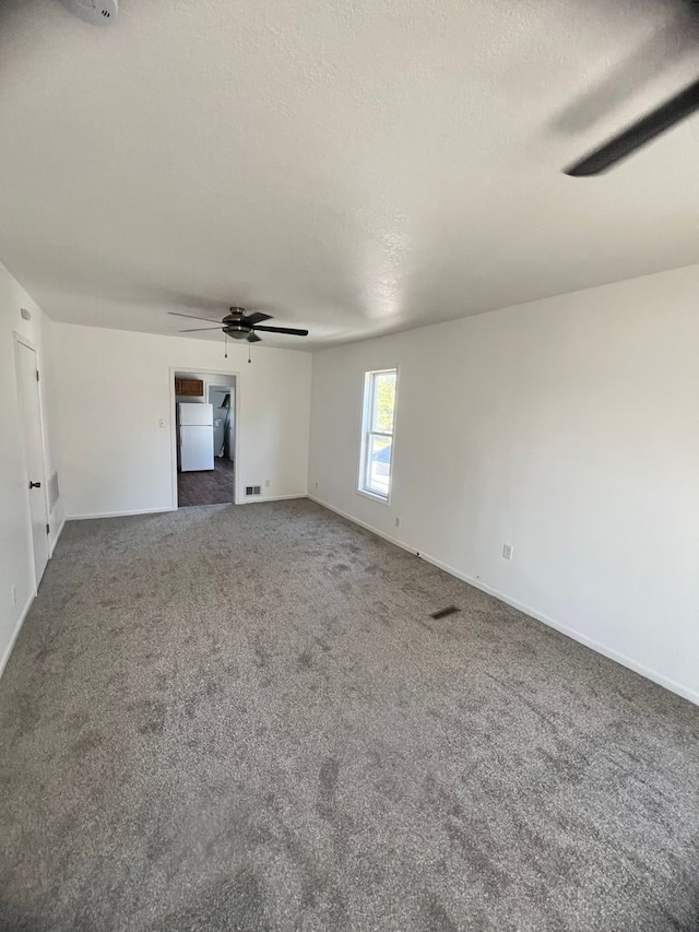 unfurnished living room with ceiling fan, a textured ceiling, and carpet