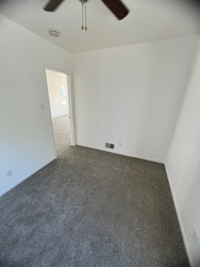 carpeted spare room with a textured ceiling and ceiling fan