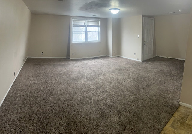 unfurnished room featuring dark carpet