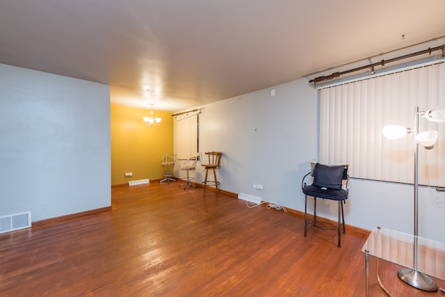 basement featuring hardwood / wood-style floors and a chandelier