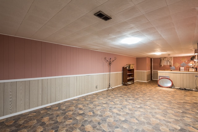 basement featuring wood walls