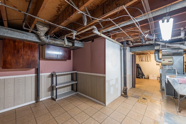 basement with wood walls and heating unit