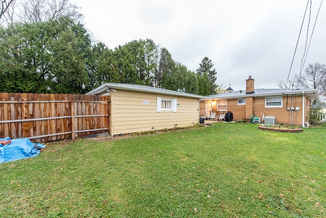 back of house with cooling unit and a yard