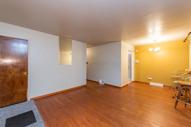 unfurnished room featuring a chandelier and wood-type flooring