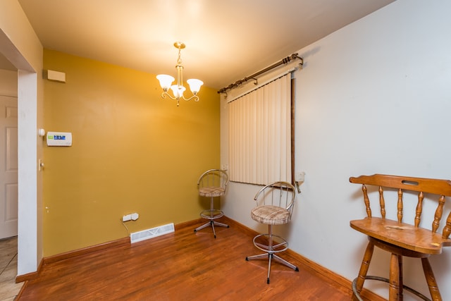 sitting room with hardwood / wood-style flooring and a notable chandelier