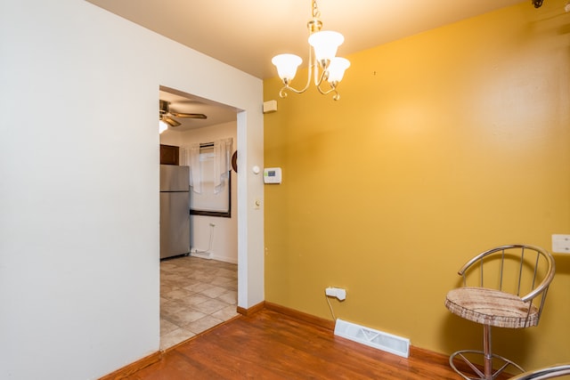 corridor with hardwood / wood-style floors and a chandelier