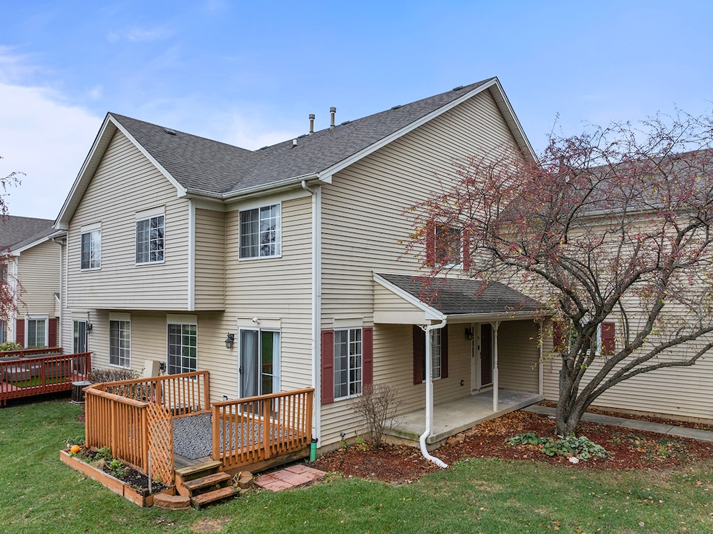 back of property with central air condition unit, a patio area, a lawn, and a wooden deck