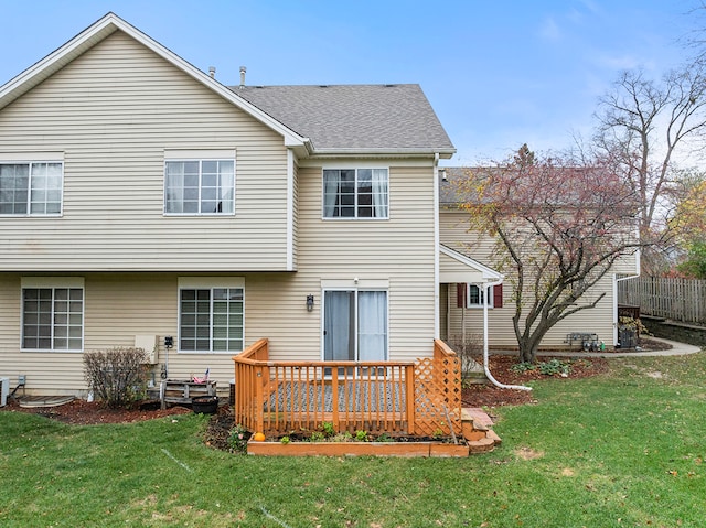 back of house featuring a wooden deck and a lawn