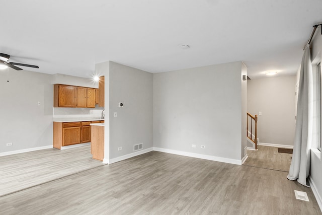 unfurnished living room with light hardwood / wood-style floors and ceiling fan