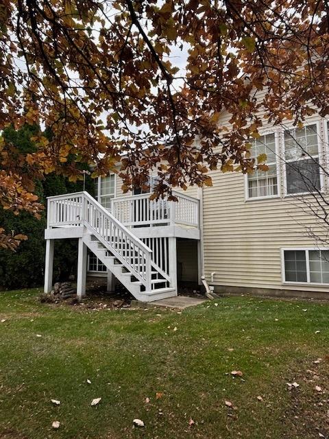 rear view of property featuring a deck and a lawn