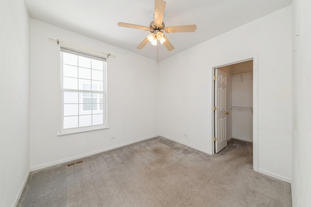 carpeted spare room with ceiling fan