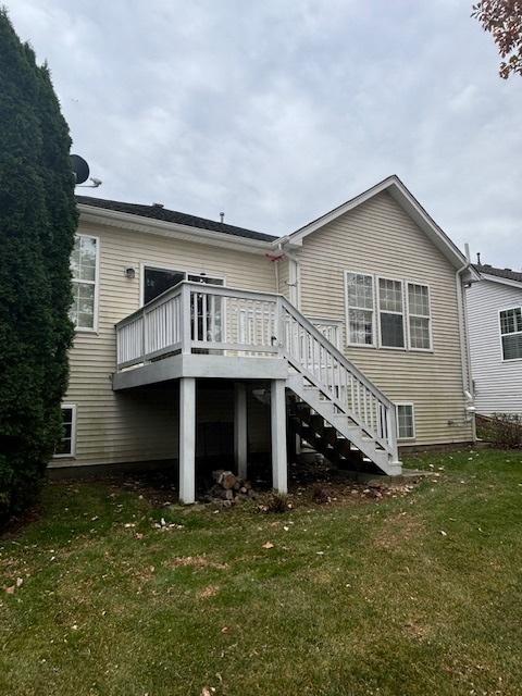 back of property featuring a yard and a deck