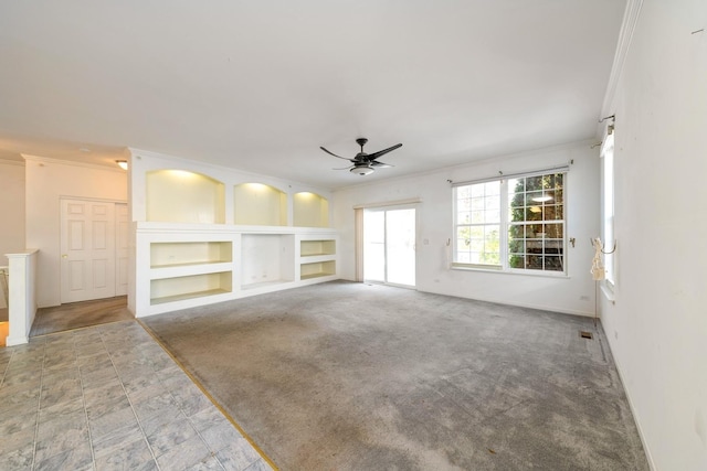 unfurnished living room featuring crown molding, built in shelves, ceiling fan, and carpet