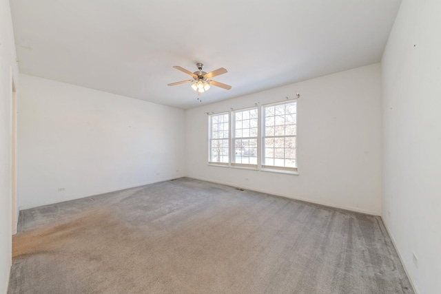 carpeted spare room with ceiling fan