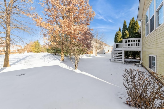 yard layered in snow with a wooden deck