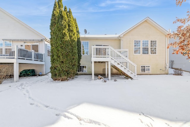 snow covered house featuring a deck