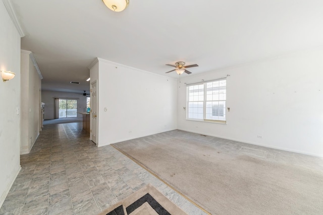 carpeted spare room with crown molding, plenty of natural light, and ceiling fan