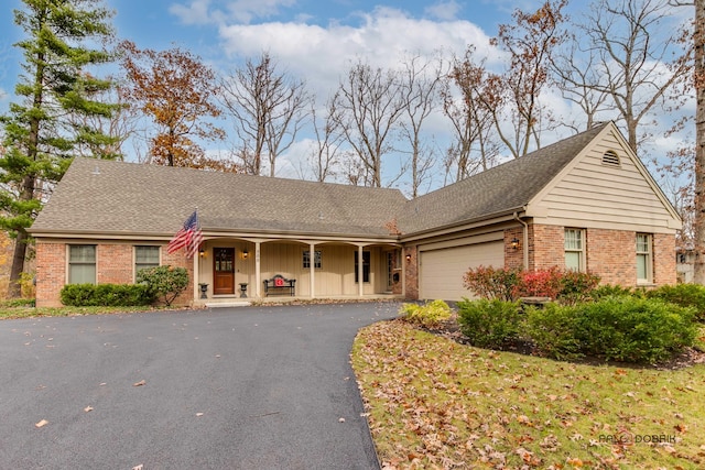 single story home featuring covered porch and a garage