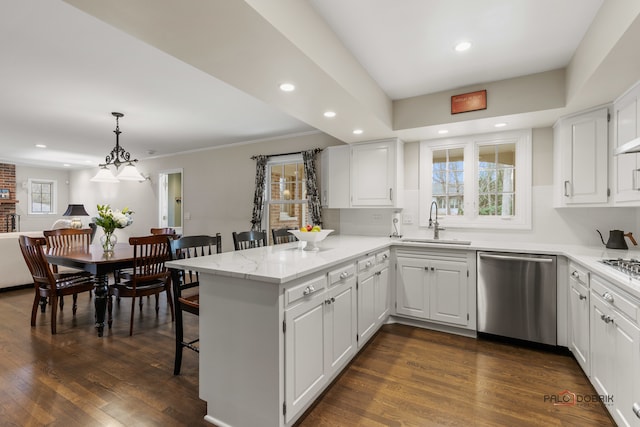 kitchen with dark wood-type flooring, sink, white cabinetry, kitchen peninsula, and stainless steel appliances