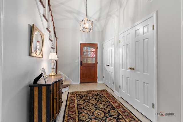 entryway with an inviting chandelier and light tile patterned flooring