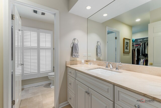 bathroom with tile patterned floors, vanity, and toilet