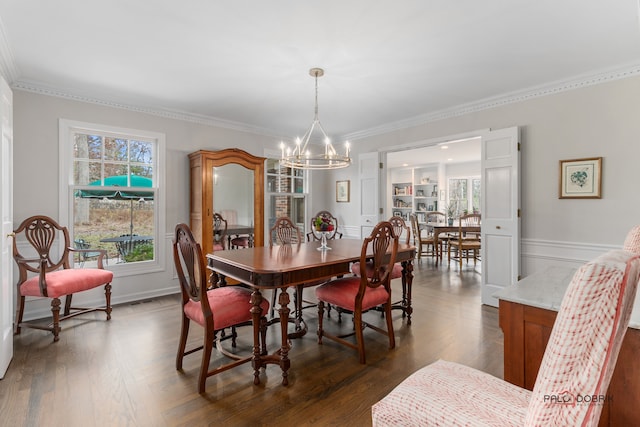 dining space featuring dark hardwood / wood-style flooring, a chandelier, and ornamental molding