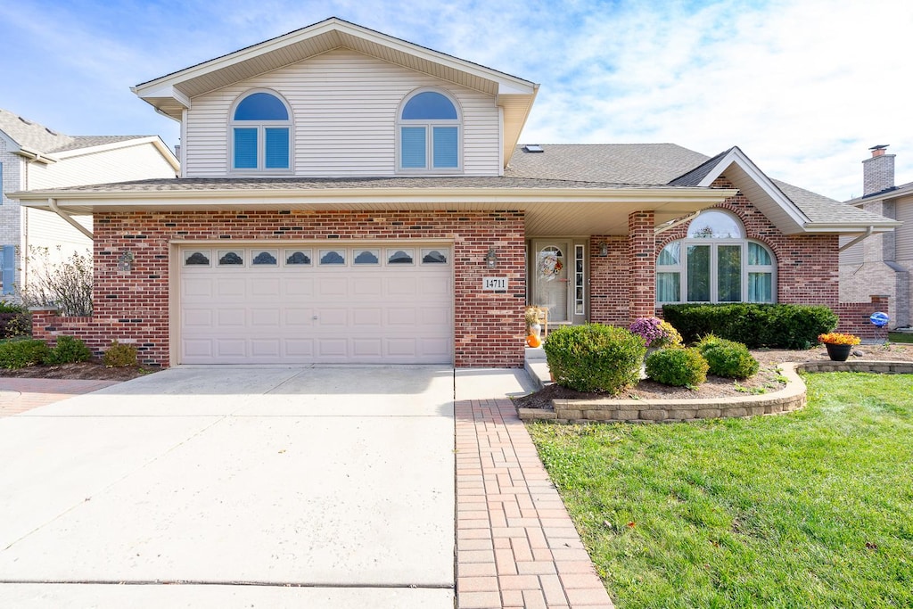 view of front of property with a garage and a front lawn