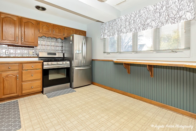 kitchen featuring stainless steel appliances and wood walls