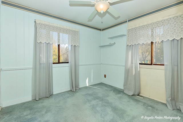 carpeted spare room featuring ceiling fan