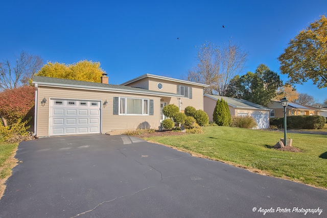 view of front of home with a front yard and a garage