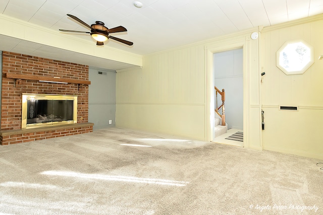 unfurnished living room with a fireplace, light carpet, crown molding, and ceiling fan