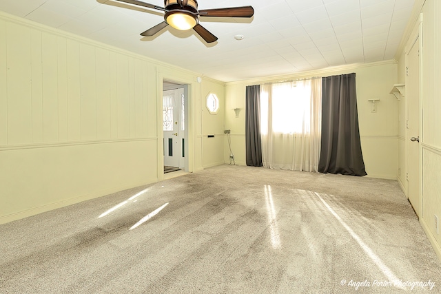 carpeted empty room featuring ceiling fan and crown molding