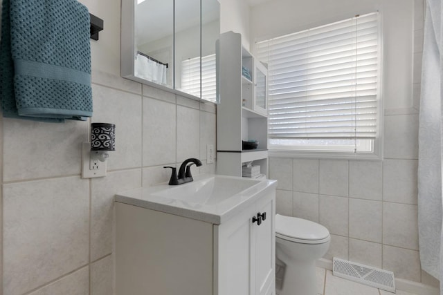 bathroom featuring tile walls, toilet, and vanity