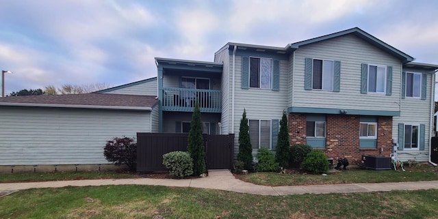 view of front of home with central AC and a balcony