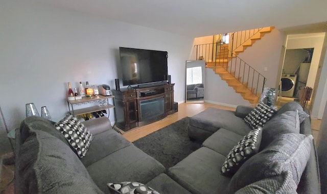 living room with a fireplace, hardwood / wood-style flooring, and washer / dryer