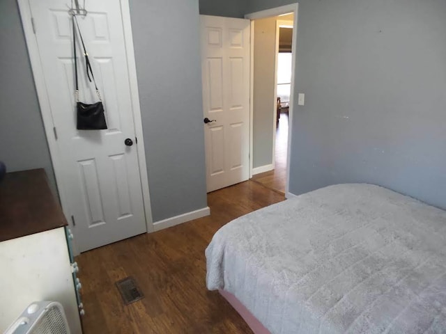 bedroom with dark hardwood / wood-style floors and a closet