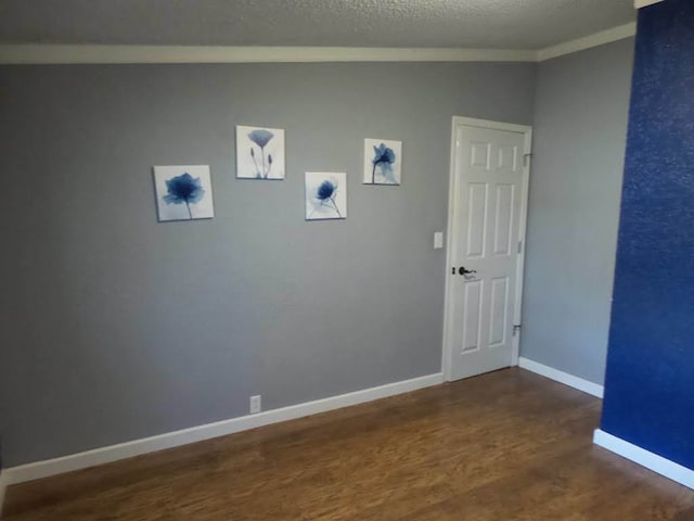 spare room featuring dark wood-type flooring, a textured ceiling, lofted ceiling, and crown molding