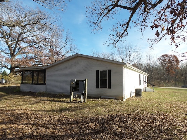 rear view of property with a sunroom and a yard