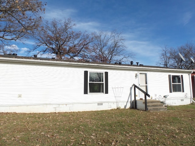 back of property featuring a lawn