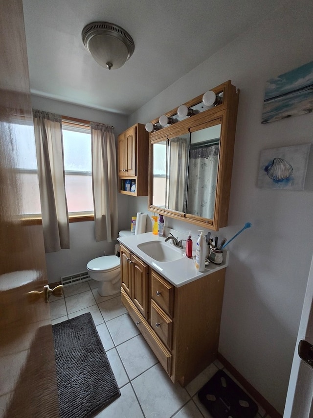 bathroom featuring toilet, vanity, and tile patterned floors