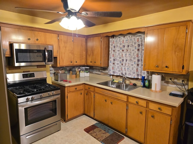 kitchen with tasteful backsplash, appliances with stainless steel finishes, sink, and ceiling fan