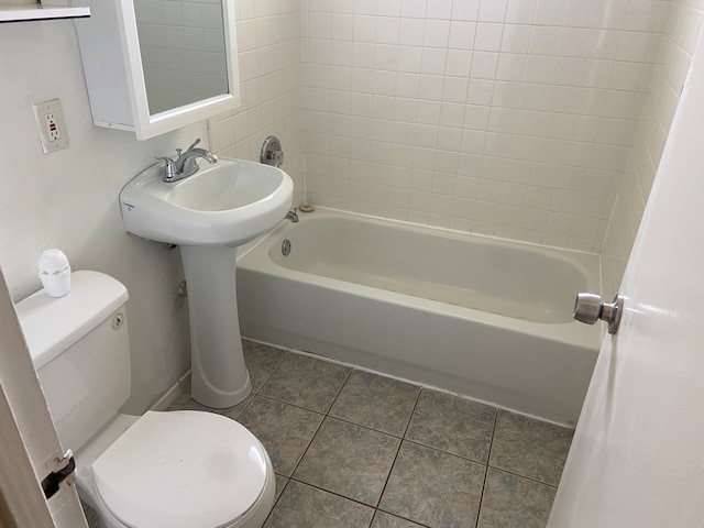 bathroom with toilet, tiled shower / bath combo, and tile patterned floors