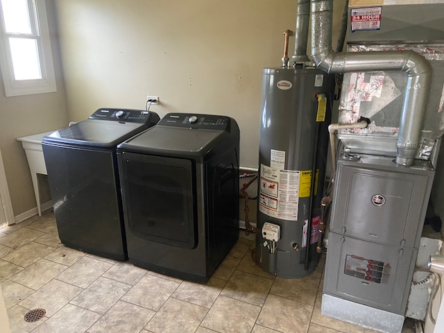 clothes washing area with washing machine and dryer, light tile patterned floors, gas water heater, and heating unit