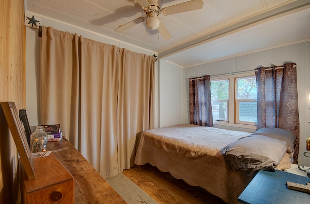 bedroom with ceiling fan, crown molding, and hardwood / wood-style flooring