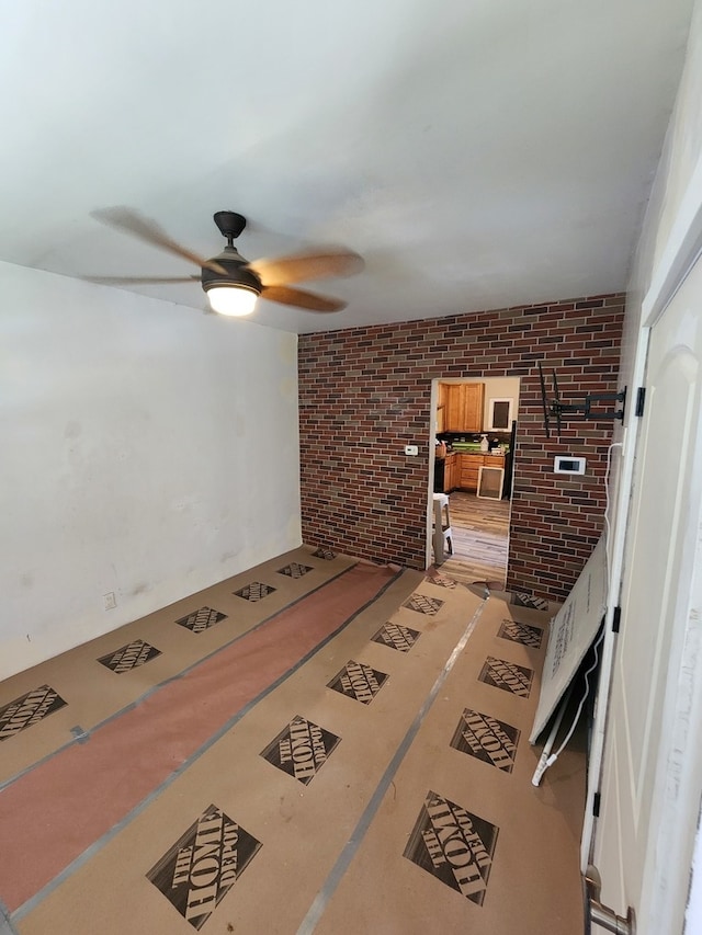 living room with brick wall and ceiling fan