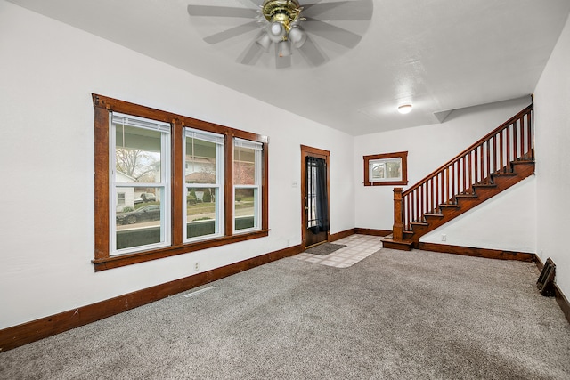 foyer entrance featuring ceiling fan and carpet floors