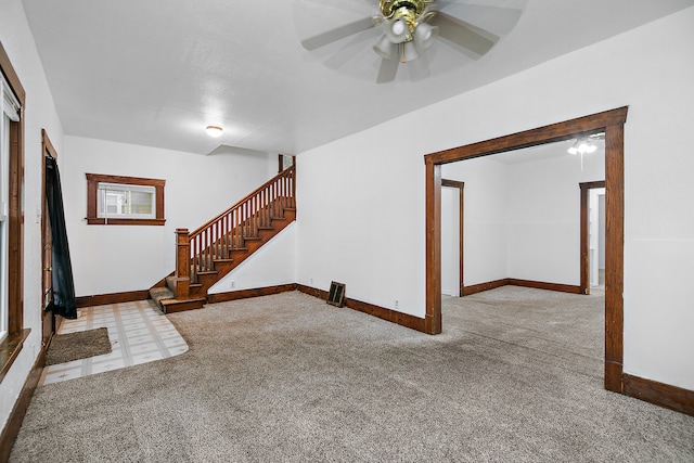 unfurnished living room featuring light carpet and ceiling fan